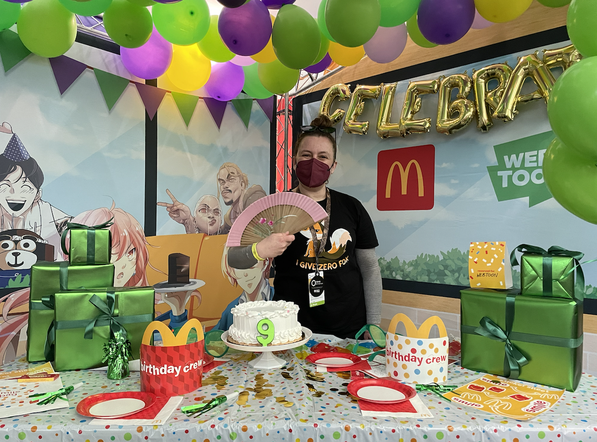 A white person stands behind a McDonald's WEBTOON birthday counter